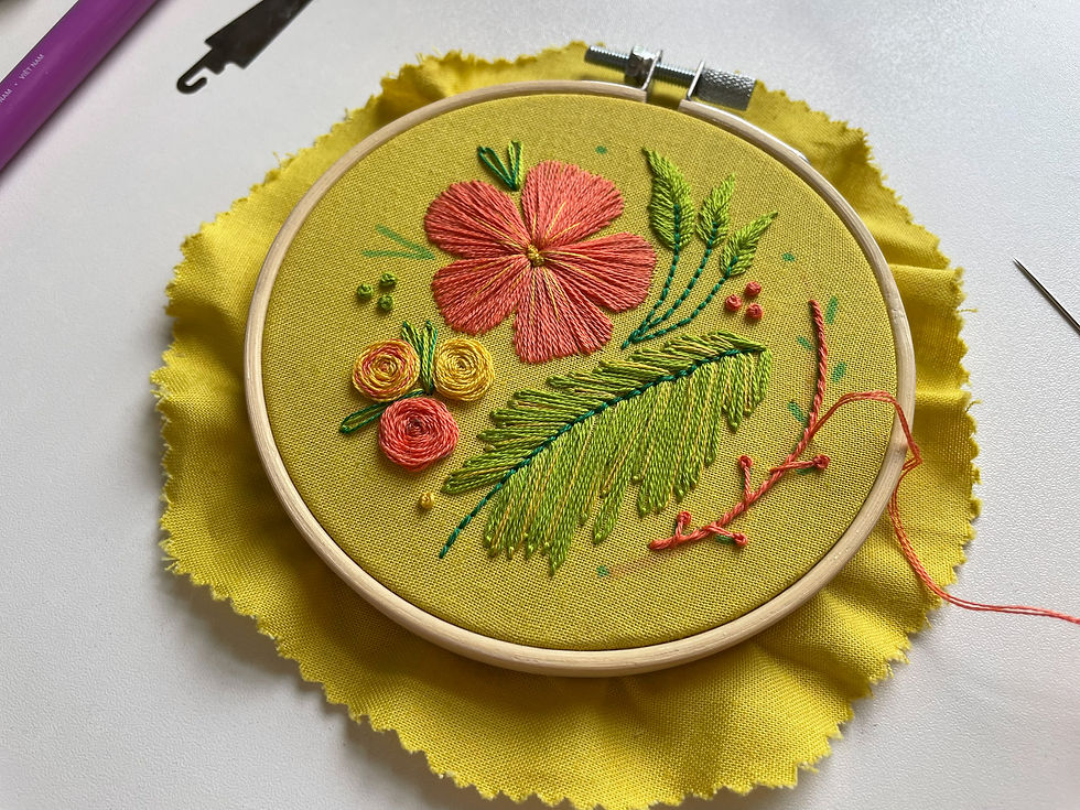 The project now has a new orange-peach vine to the right, and embellishments stitched in variegated light and green floss to replace the dark green French knots in the last photo.