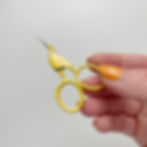 Thumbnail: A pair of small, stork-shaped embroidery scissors in yellow.