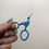 Thumbnail: Hope holds up a pair of small blue stork embroidery scissors.