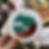 Thumbnail: An embroidery hoop with a landscape stitched in maroon, deep orange, pink, and blue on white fabric.