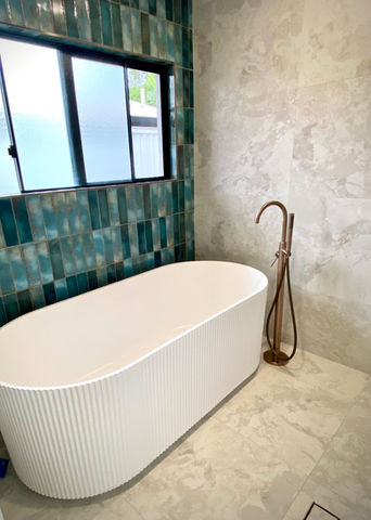 Freestanding, fluted bath with brushed bronze bath filler