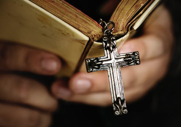 Christin cross from a book and book in hands