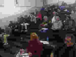 Auditório quase lotado com pessoas com muitas roupas de frio