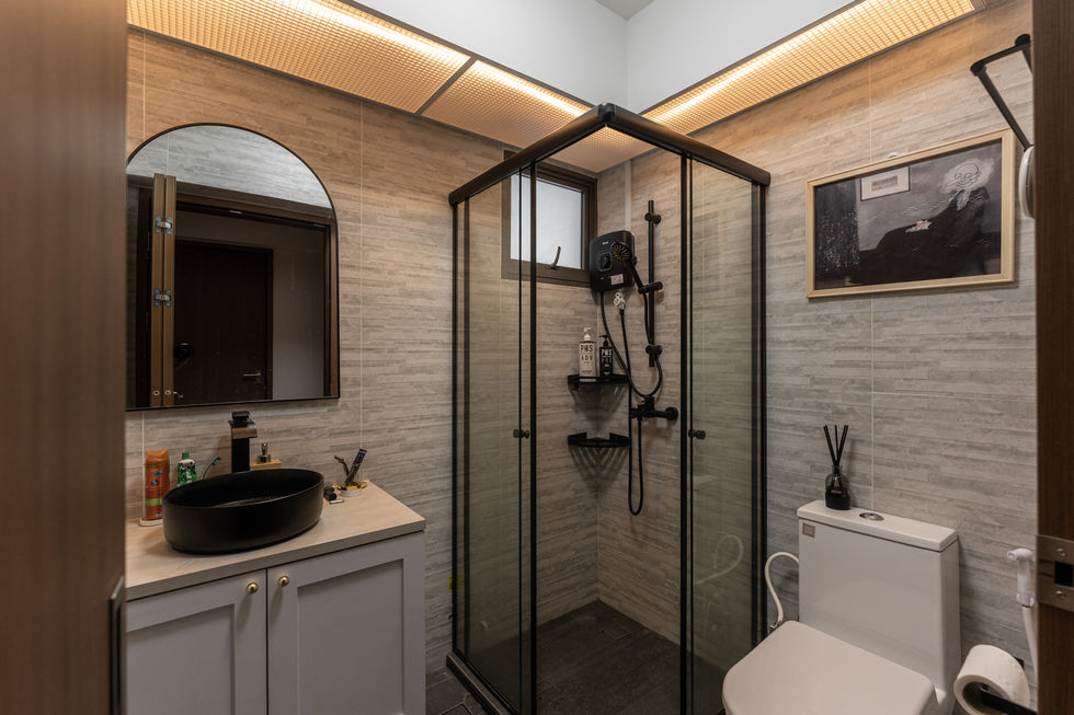 Echoing the home's modern and cozy aesthetic, the bathroom is designed with clean lines, neutral tones, and thoughtful functionality. Soft grey tiles stretch across the walls and floor, creating a cohesive and calming atmosphere that complements the rest of the interior