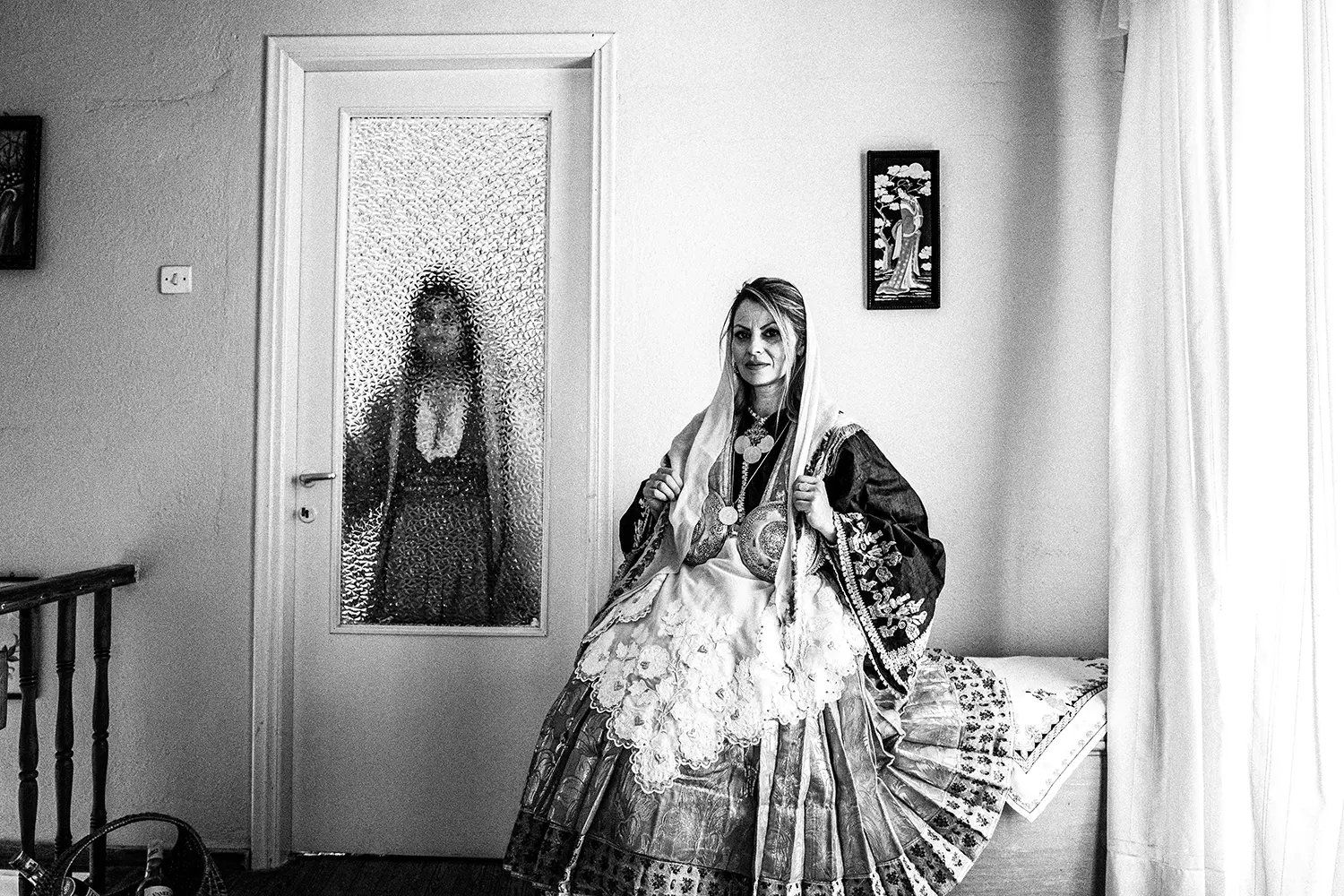 Two women inside a home, wearing the local attire of Trikeri, Thessaly, Greece. Black and white photography by George Tatakis