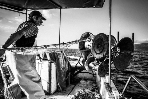 Yorgos pulling up the net , Diafani, Olympos, Karpathos, Greece. Black and white photography by George Tatakis