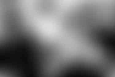 A kid eating candy with two women in traditional clothes, at the local cemetery. Olympos, Karpathos, Greece. 