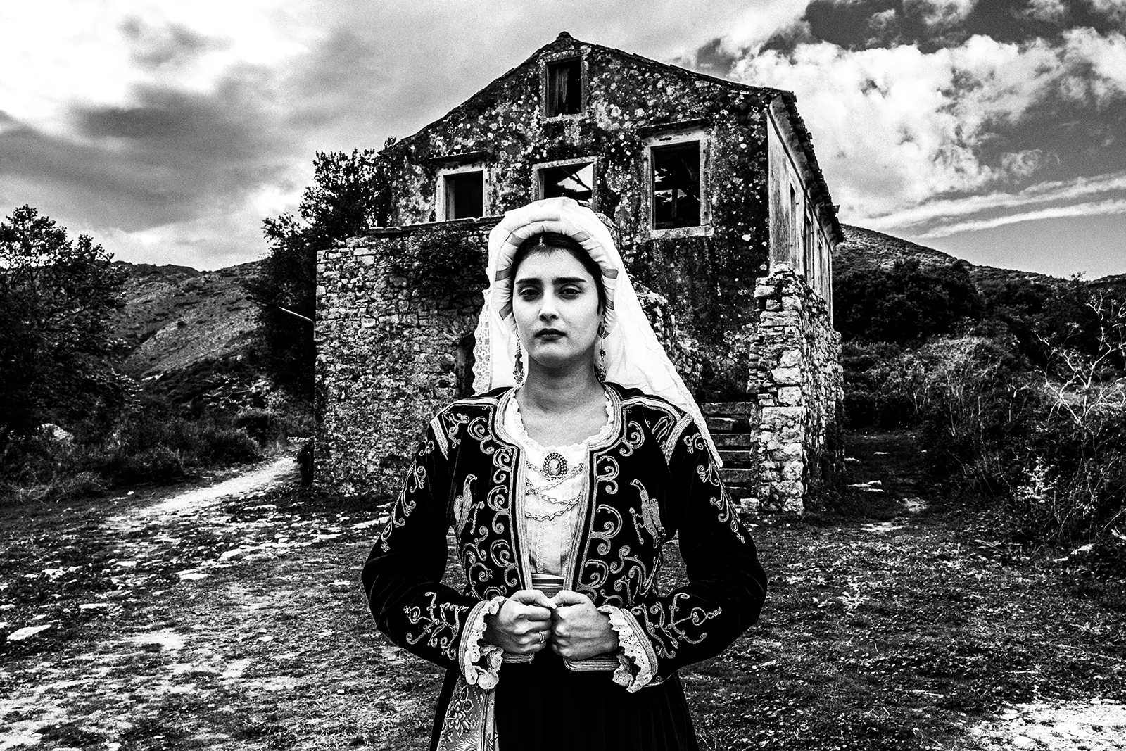 Τοπική γυναικεία φορεσιά μπροστά από ένα εγκαταλελειμμένο σπίτι στην Παλαιά Περίθεια, Κέρκυρα, Ελλάδα -- του Γιώργου Τατάκη