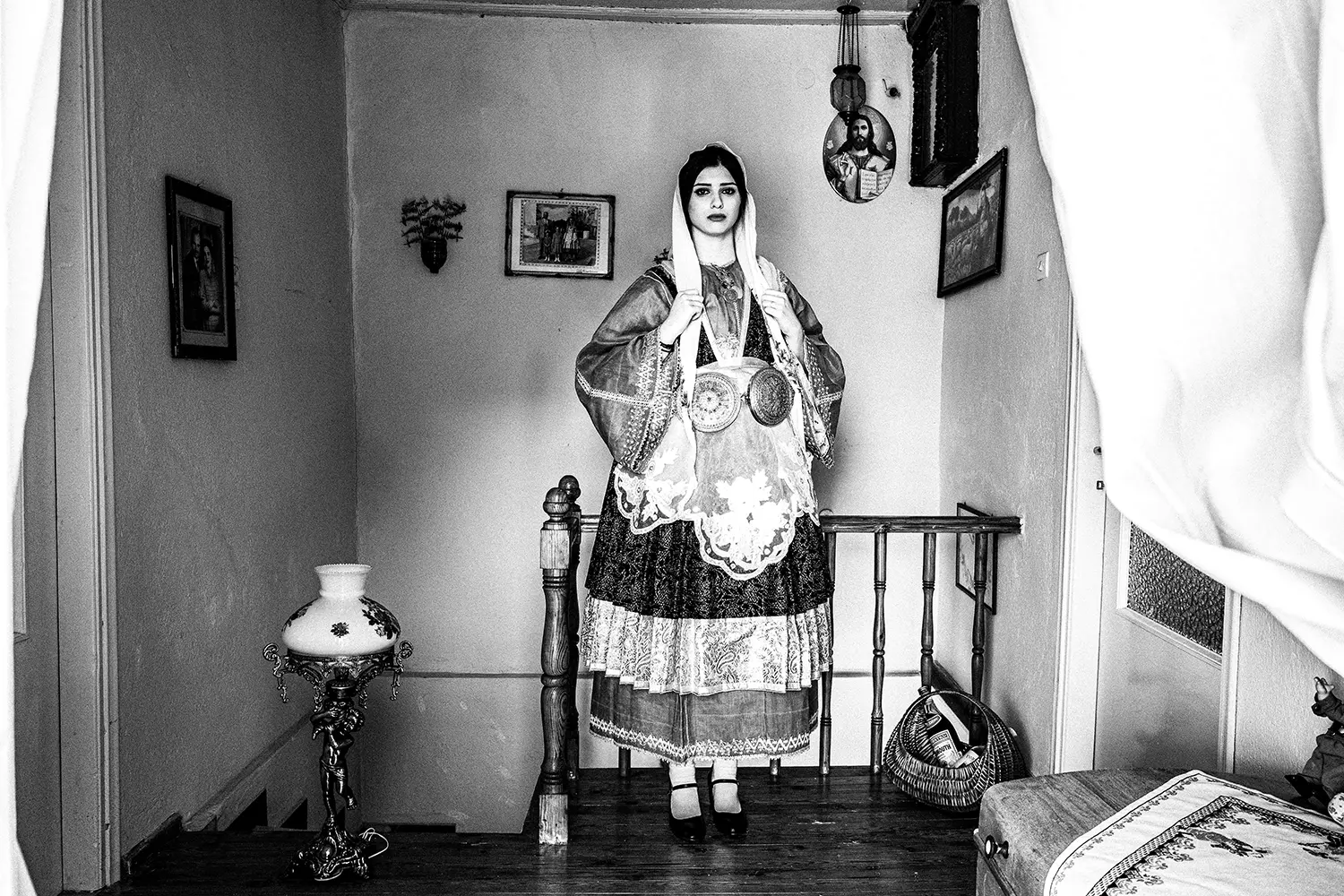 A beautiful girl by a staircase, wearing the traditional costume of Trikeri, Thessaly, Greece. Black and white photography by George Tatakis
