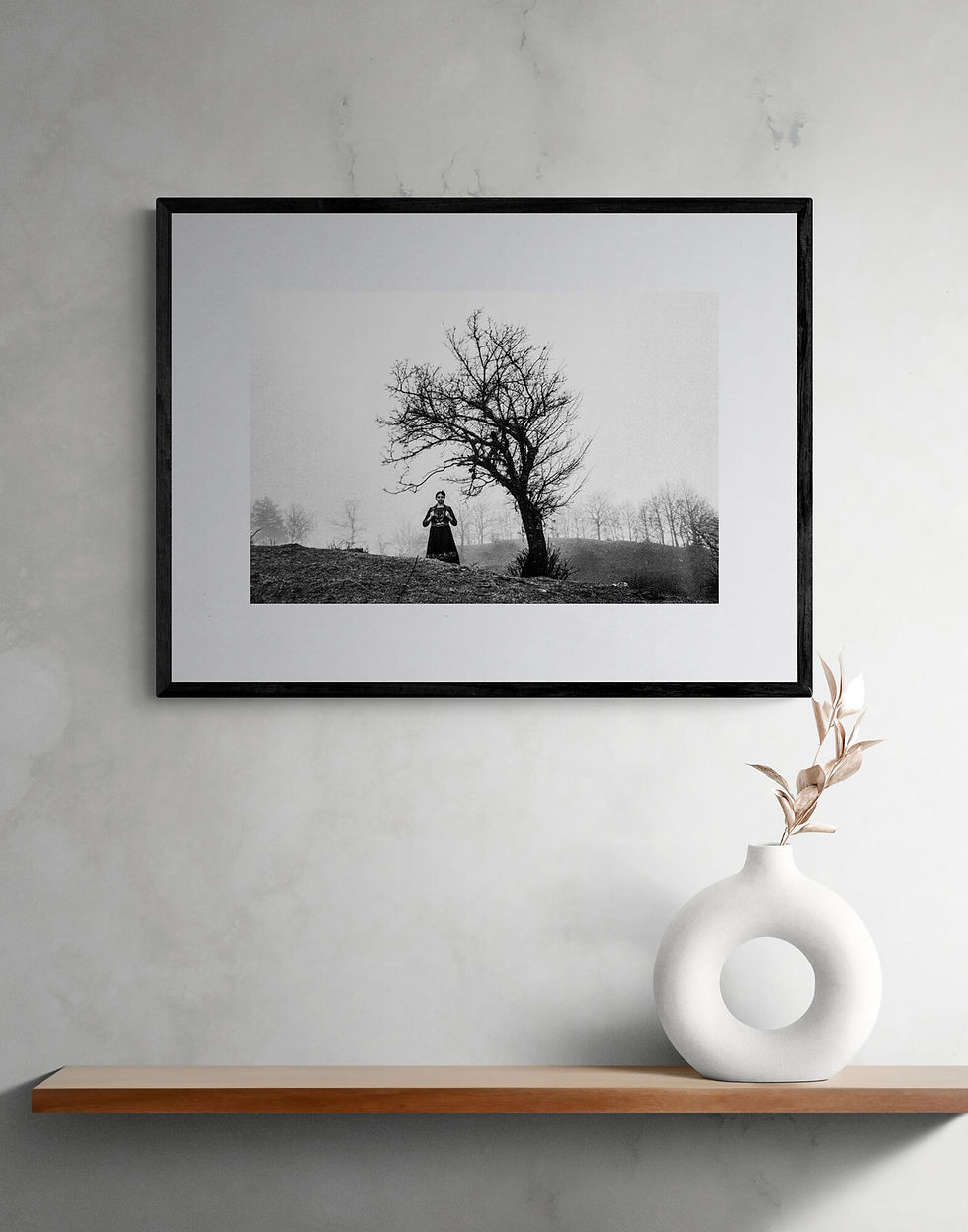 Woman next to a leaveless tree in Epirus, Greece. Black and white photography by George Tatakis