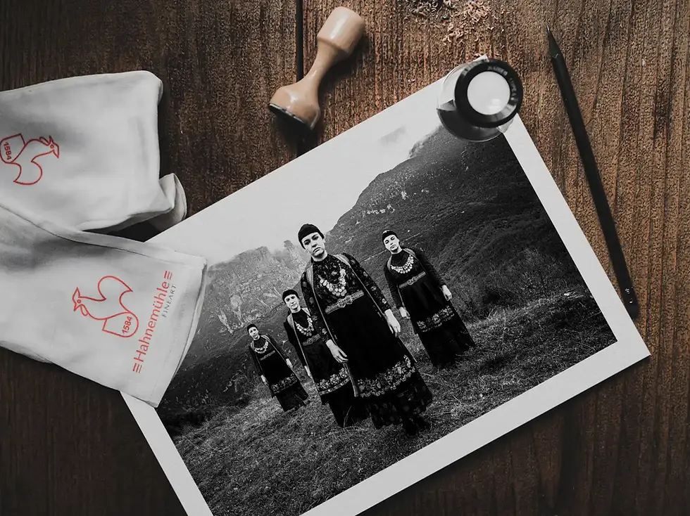 Women in the local dresses of Zagori, overlooking Papigo mountains, Epirus, Greece. A fine-art black-and-white photographic print on a wooden table, by George Tatakis.