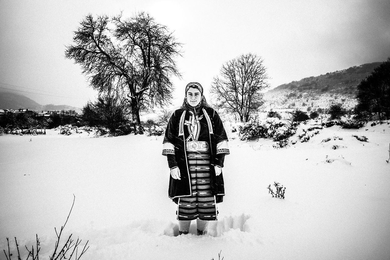 An Olympic athlete wearing the folklore dress of Volax in the snow, Macedonia, Greece. Black and white photograph by George Tatakis