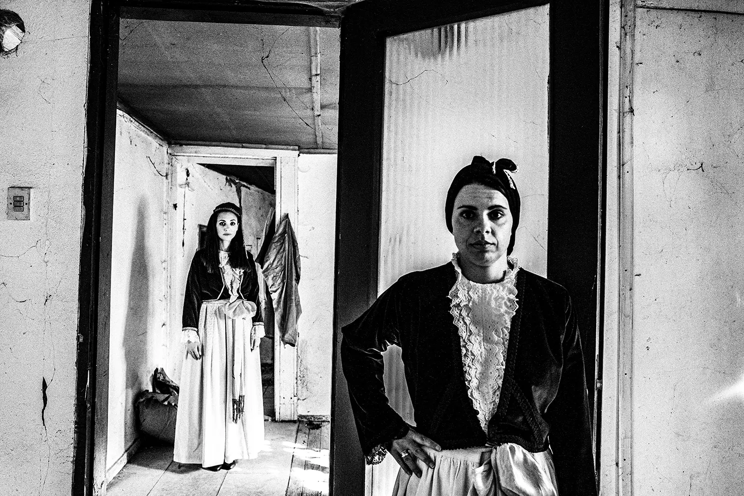 Two women in an abandoned home, wearing the folklore dresses of Pelion, Thessaly, Greece. Black and white photography by George Tatakis