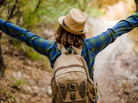 Embracing tranquility, a woman strolls through a serene forest path, relishing the stress-relieving embrace of nature.
