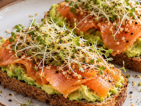 Smoked salmon avocado gluten-free toast topped with broccoli sprouts and everything bagel seasoning.