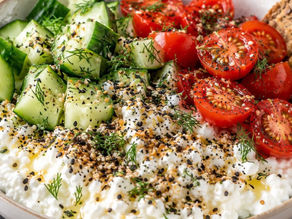 Savory cottage cheese bowl with cucumber, cherry tomatoes, fresh dill, everything bagel seasoning and seeded crackers.