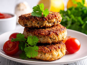 Gluten-free salmon patties with fresh dill, chives, and lemon wedges.