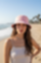 Rosa Bucket Hat, getragen von einem jungen Mädchen mit langen braunen Haaren am Strand.
