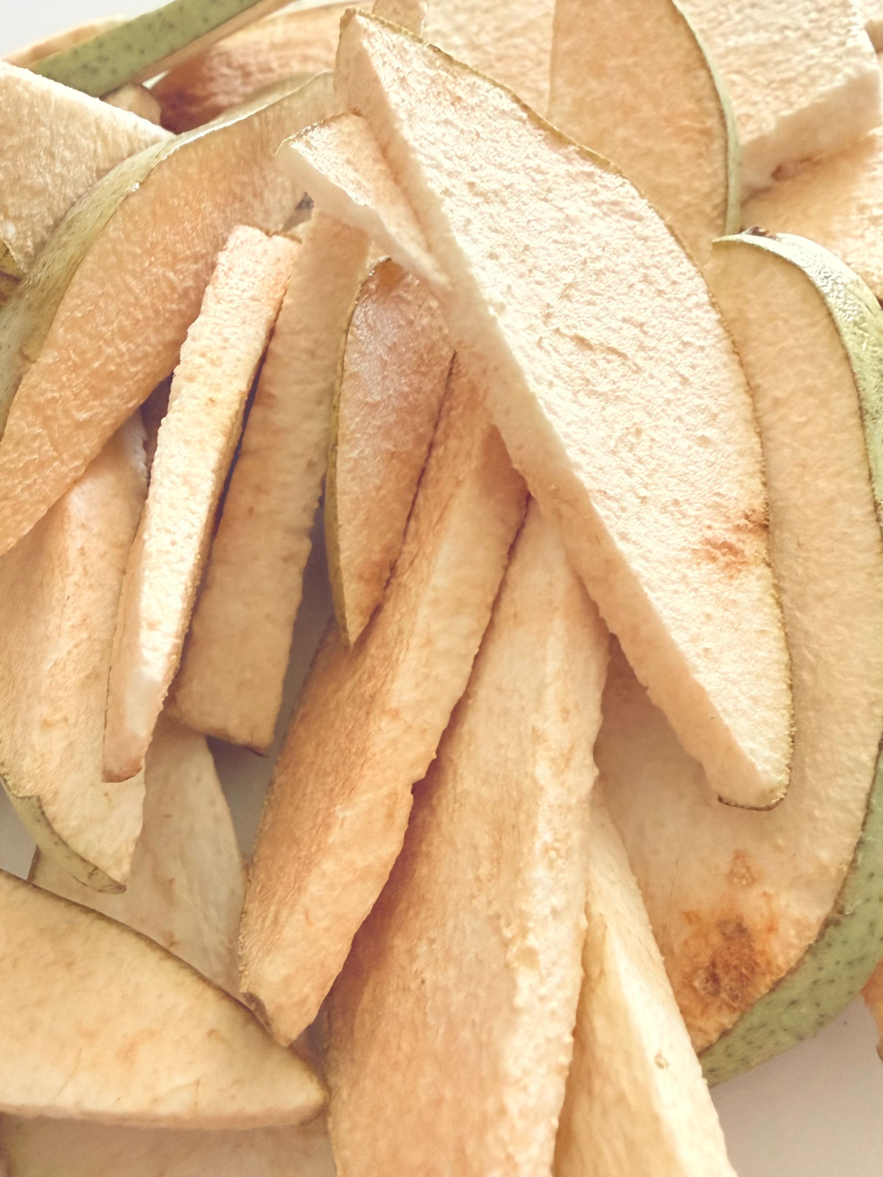 Slices of freeze-dried pears with green skin.
