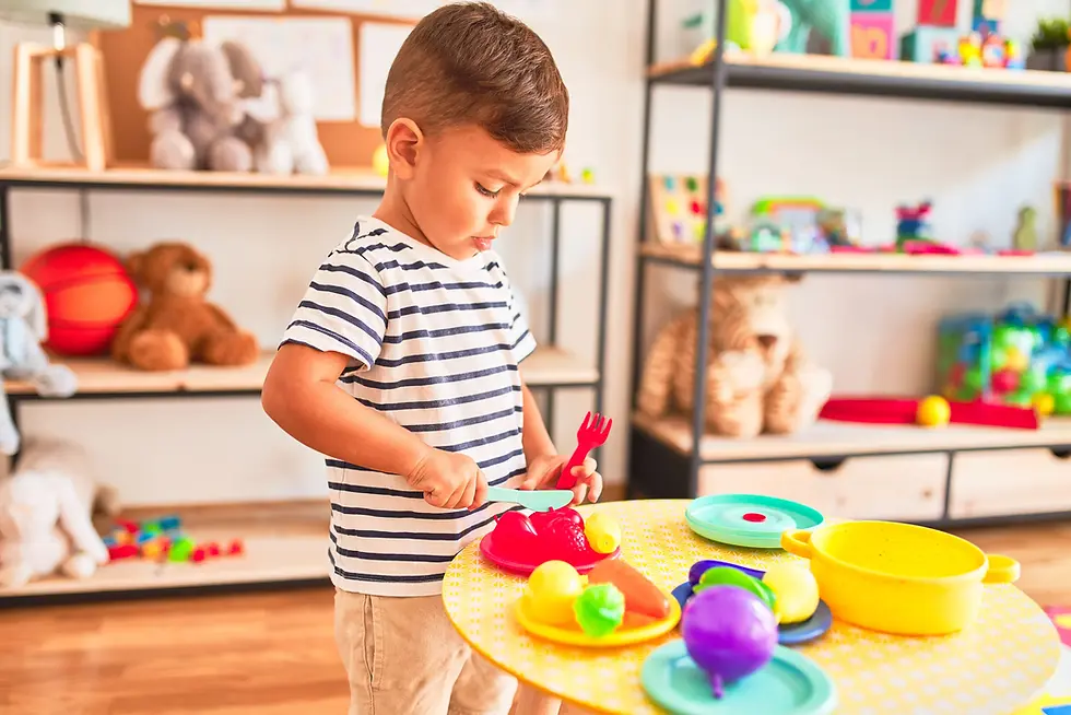 Un niño jugando con juguetes de cocina plásticos.