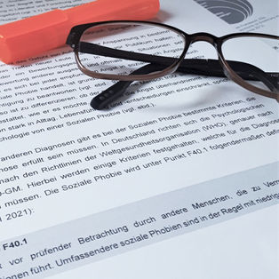 A pair of glasses and a marker lie on a scientific paper