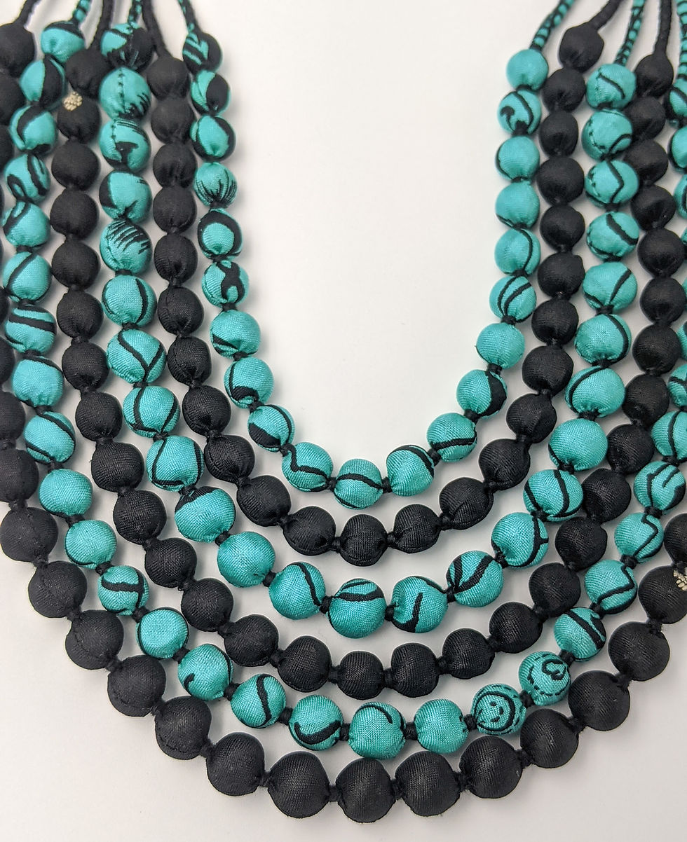 Thumbnail: Front view of a unique, mint-and-black sari silk necklace made from upycled saris wrapped around wooden beads