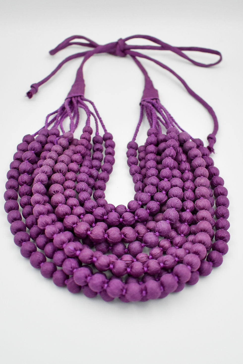 Thumbnail: Flat view of a silk sari necklace meticulously  handcrafted by women.  A zero-waste product made from upcycled silk saris.