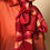 Thumbnail: Woman wearing a red silk shibori scarf in a bow around her neck