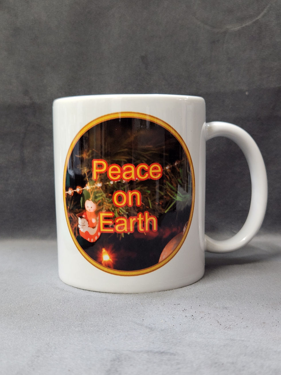 White mug with "Peace on Earth" text and Christmas decorations background.