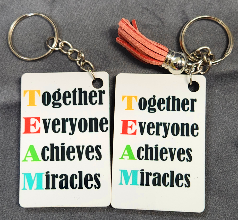 Two keychains with TEAM text: Together, Everyone Achieves Miracles. Designed by Sylvia V's Creation.