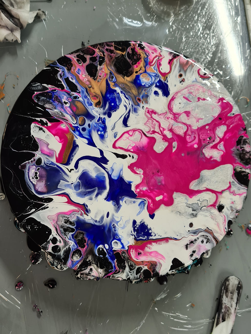 Abstract art with black, white, pink, and blue resin on round coaster