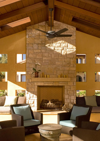 Luxury outdoor living cabana with stone fireplace and soft seating area.