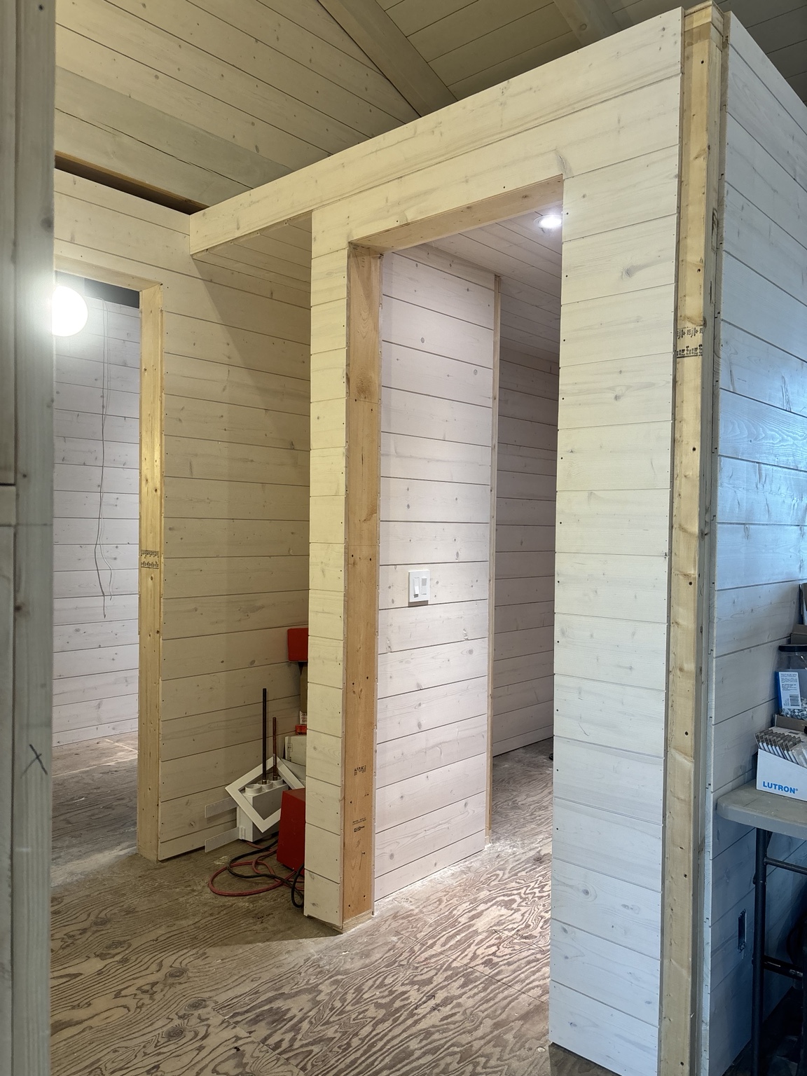 Wide wood casing around a doorway between two panelled rooms
