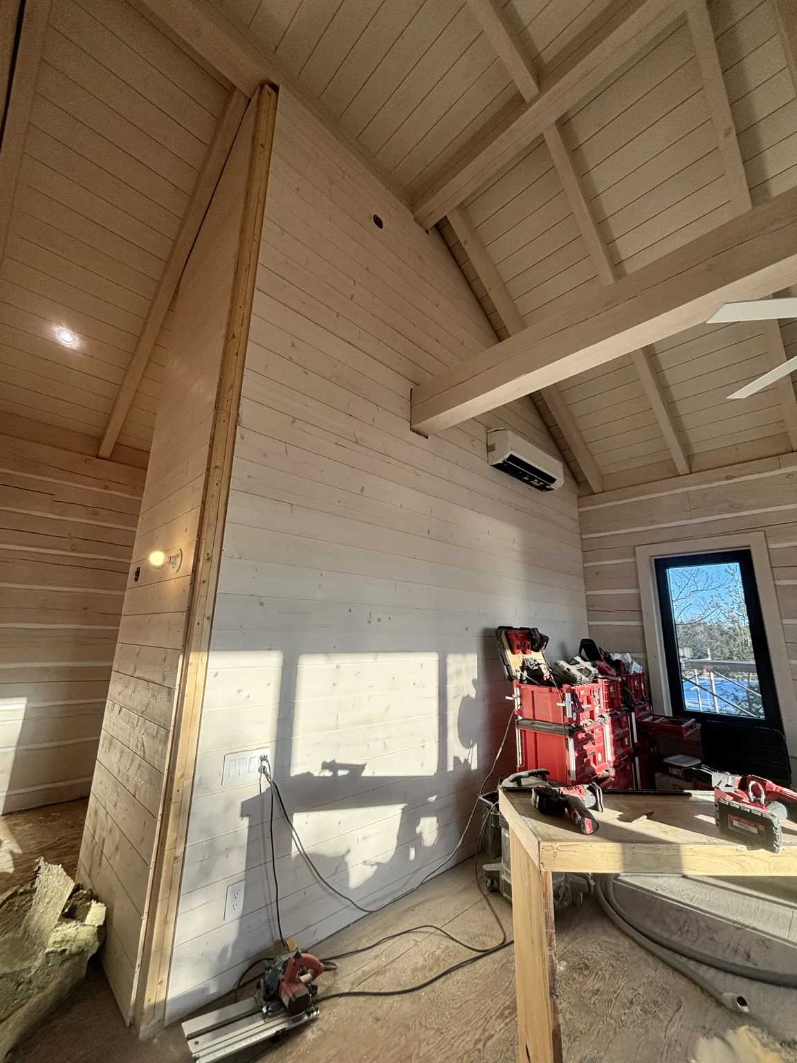 Shiplap walls rising to a detailed vaulted ceiling during installation