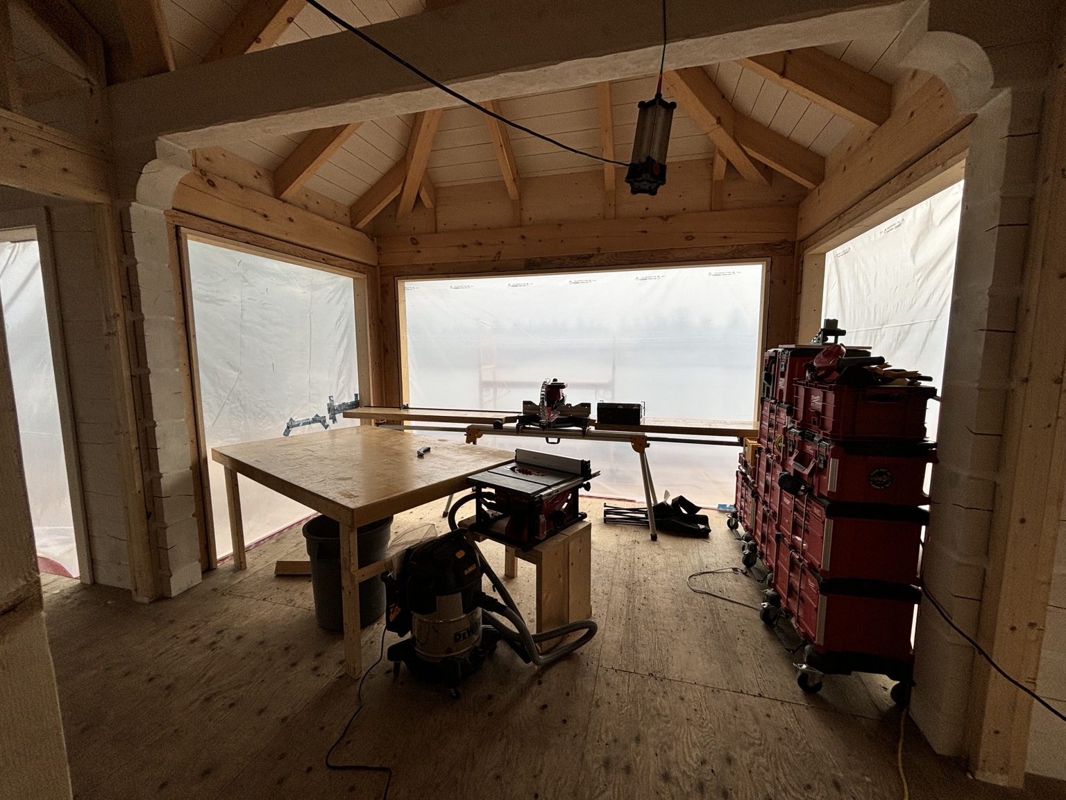 Portable carpentry station and Packout stacks in the timber-framed room