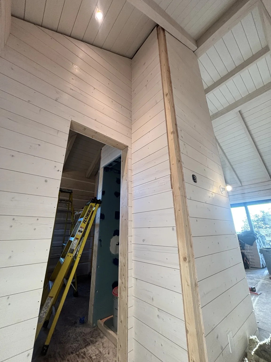 Horizontal wall boards fitted around a doorway and a tall partition