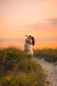 Couple kissing in sand dunes at sunset photoshoot in St. Augustine Florida