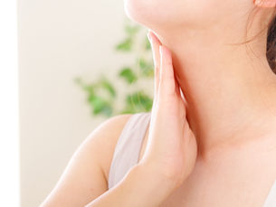 女性が首のリンパを触っている