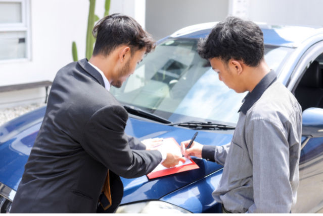 Teen reviewing car loan paperwork with lender requiring a co-signer for approval