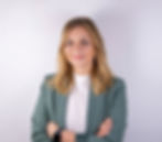 Magdalene Parma in grünem Blazer mit verschränkten Armen, vor hellem Hintergrund und freundlichem Gesichtsausdruck