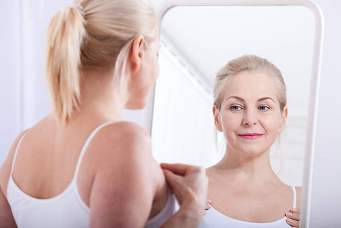 middle-aged-woman-looking-at-wrinkles-in-mirror-selective-focus(1).jpg