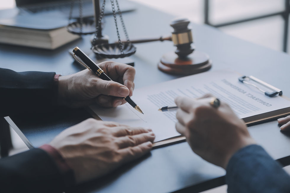 Two individuals reviewing and signing a legal contract at a desk, with a gavel, scales of justice, and legal books in the background, symbolizing careers in criminal justice and legal studies.