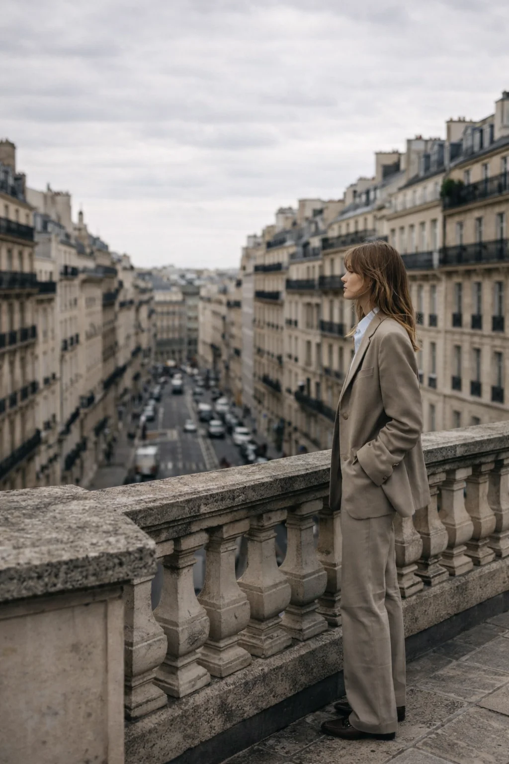 mujer de perfil con traje de color beige mirando a los edificios 