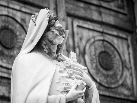 A crumbling statue of a religious human