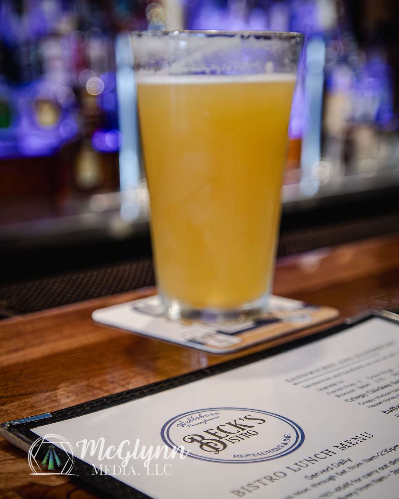 A menu for Beck's Bistro sitting on a bar with a pint in the background.
