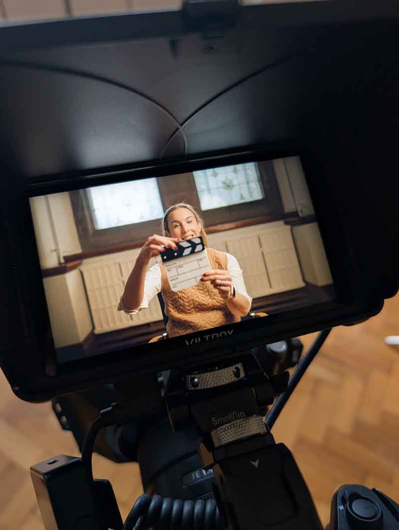 A women holds up a videography clapperboard