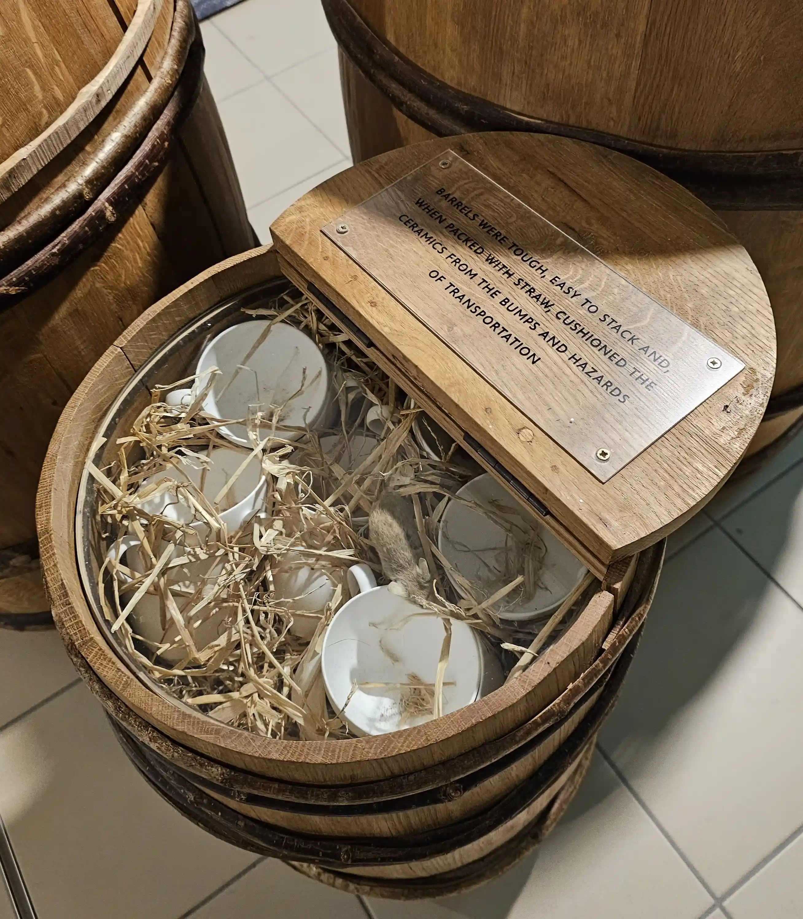 World of Wedgwood V&A Museum exhibit of an open barrel with straw inside, holding several white pieces of ceramics