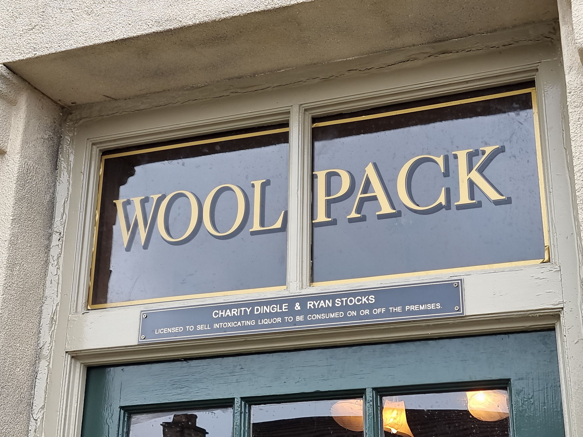 woolpack entrance door with glazed panel and a sign stating that charity dingle and ryan stocks are the landlords