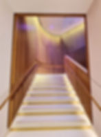 staircase and wood panelling at johnnie walker princes street edinburgh. it is made from oak strips on the walls and white stone stair treads that are illuminated.