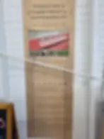 Sign reading "Pendleton's Commitment to Sustainability" on a wooden board with text about wool production. White wall in background.Pendleton Woolen Mill Tour Washougal.